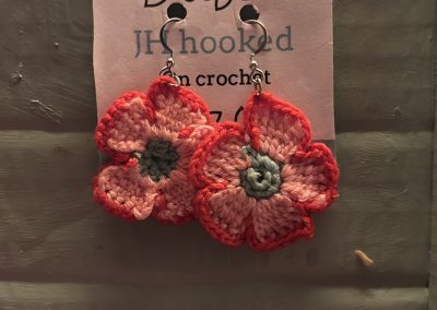crochet retro flower earings made with 100% cotton crochet thread and hypoallerginic finding. featuring pink petals with a darker pink outline and a sea foam green center