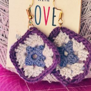 artisan crochet granny square earings made with 100% cotton embroidery thread. Starting with a blue center, then a round of light gry with a purple trim. the findings are hypoallerginic.